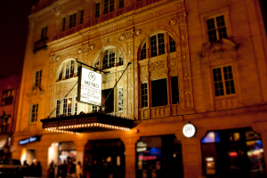 Ein gelbes Gebäude mit Geschäften im Erdgeschoss, eines davon hat ein weißes Schild mit der Aufschrift 'Metro'.