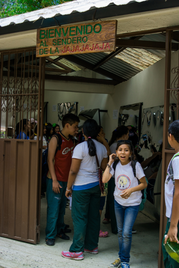 Ein Laden mit einem Eisentor und einer Schiefertafel mit Text oben drauf, mit Menschen drinnen.