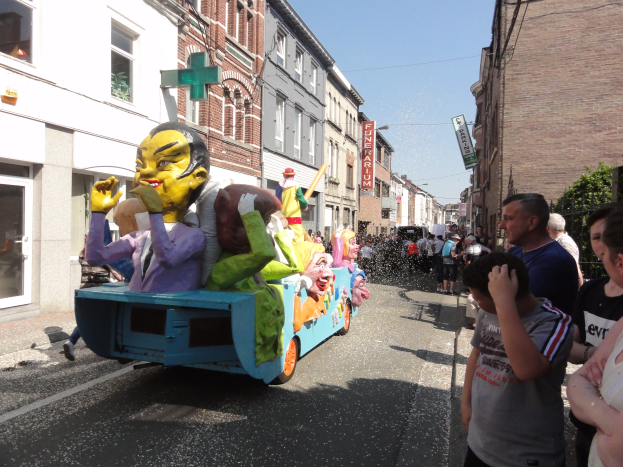 Eine Gruppe von Menschen auf einem bunt verzierten Spielzeug-Schwimmwagen bei einem Umzug.