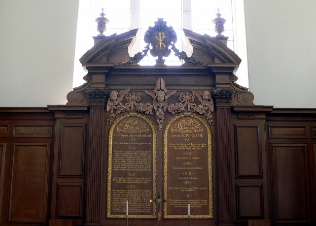 Eine Museumsplakette mit Text und Skulpturen darauf.