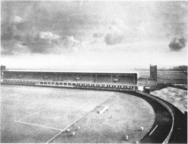 Schwarzes und weißes Foto eines Fußballfeldes mit einem Stadion, das von Bäumen umgeben ist und ein bewölkter Himmel, mit dem Text "Stoke City Football Club" unten.