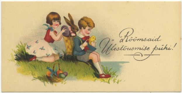 Alte Postkarte mit zwei Kindern auf dem Gras, eines hält einen Korb mit Ostereiern und das andere ein Spielzeug, mit einem Textplakat im Hintergrund.