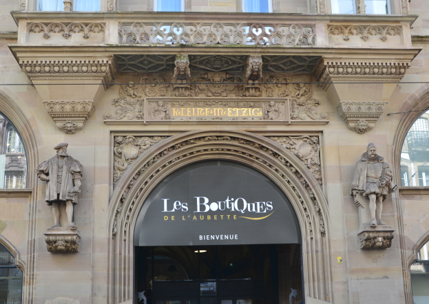 Der Eingang zu Les Boutiques de l'Aubette in Paris, Frankreich, mit einem Glasfenstergebäude, Skulpturen und einer Namenstafel mit der Aufschrift "Les Boutiques".