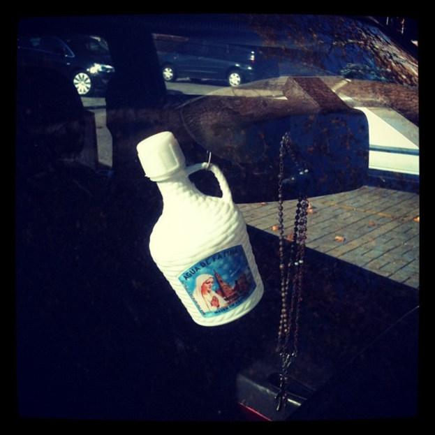 Ein Auto steht mit einer Kette und einer Flasche daneben auf dem Seitenstreifen.