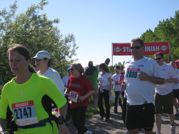 Eine Gruppe von Kindern beim Marathonlauf mit einer roten Fahne und Bäumen im Hintergrund.