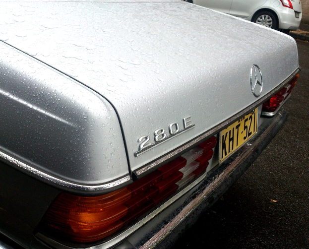 Ein Mercedes-Benz-Fahrzeug auf einer Straße mit einem anderen Fahrzeug daneben.