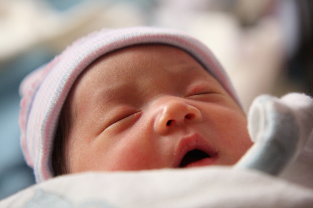 Ein schlafendes Kind ist im Vordergrund mit einem unscharfen Hintergrund.