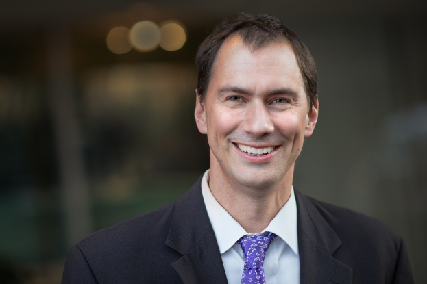 Ein Mann im Anzug, der lächelt.