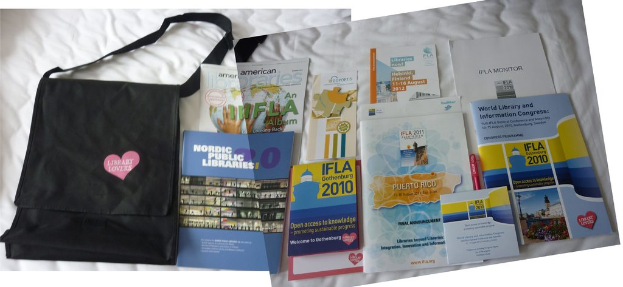 Eine Tasche mit der Aufschrift "Bibliothekliebhaber" und einige Bücher auf einem Bett.