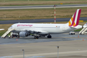 Ein geparktes Germanwings Airbus A320-200-Flugzeug am Frankfurter Flughafen, mit Fahrzeugen, Verkehrskegeln, Pfählen und Gras im Hintergrund.