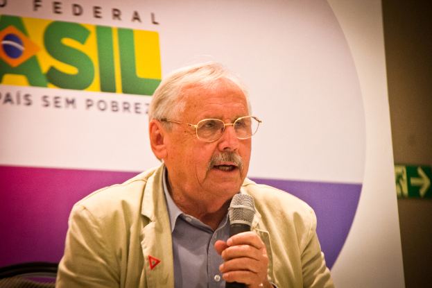 Eine Person hält ein Mikrofon vor einem Banner mit der Aufschrift 'Bundes'.