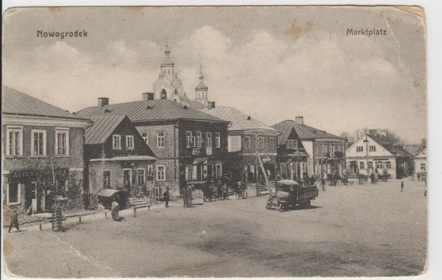 Schwarze-Weiß-Fotografie einer Straße in Nowogrodziec, Deutschland, mit Gebäuden, Menschen, Wagen, Pfölen, Bäumen und Himmel mit Text "Marktplatz in Nowogrodeek, Deutschland" oben und unten.