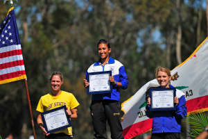 Drei Frauen mit Zertifikaten und Flaggen vor Bäumen