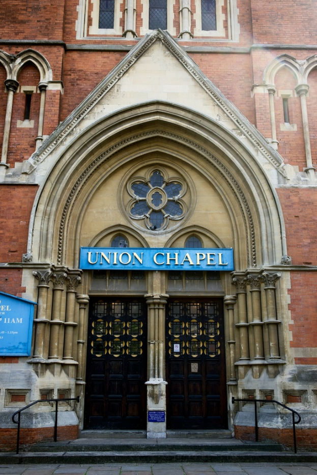 Eine große historische Kirche in London mit zahlreichen Fenstern an den Wänden und zwei Türen am Eingang.