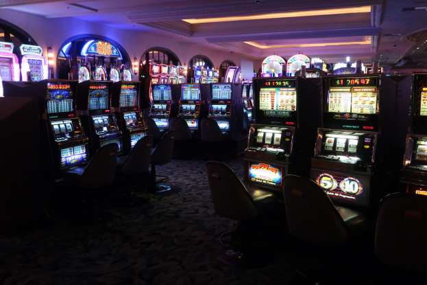 Reihe von Spielautomaten zum Verkauf in einem Casino, mit Stühlen und Deckenlampen.