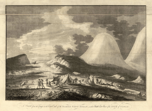 Eine Gruppe von Menschen, die vor einem Berg an der Ostseite von grasbewachsenen Sandhügeln unter einem bewölkten Himmel stehen, mit Text am unteren Rand des Bildes.