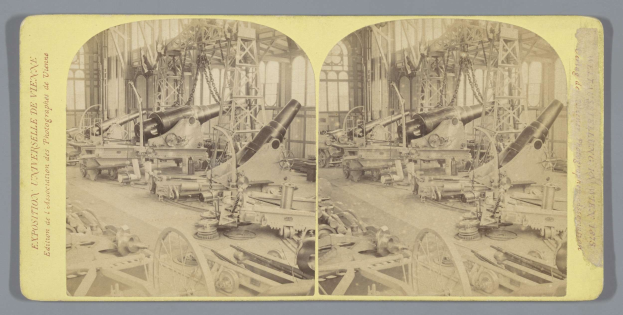 Schwarzes und wei├čes Foto einer Fabrikhalle mit einem gro├čen Geschütz in der Mitte, umgeben von anderen Geschützen, Metallstangen und Gegenst├Ąnden auf dem Boden, mit Text auf der linken Seite.