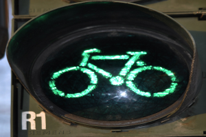 Grüne Ampel mit Fahrradsymbol vor einer Wand im Hintergrund.
