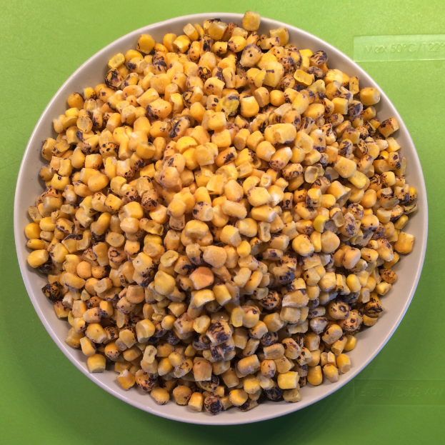 Ein weißer Schüssel mit Maiskörnern wird gegen einen grünen Hintergrund mit Text unten platziert.