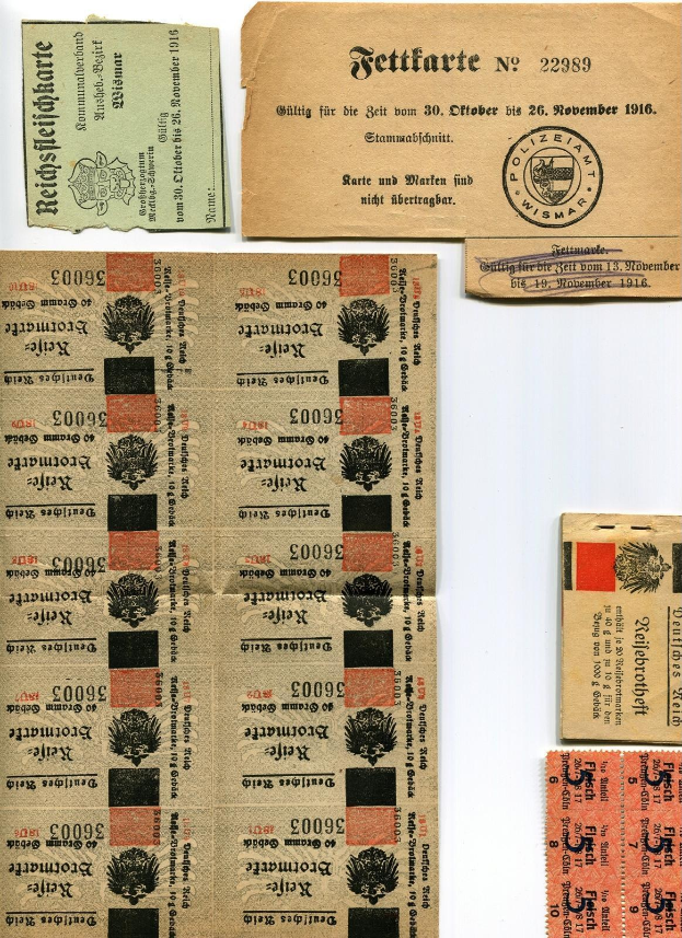 Sammlung alter deutscher Tickets und Marken auf einem weißen Hintergrund, mit abgenutztem Papier und gedrucktem Text und Zahlen.