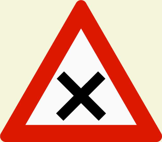 Ein rotes und weißes dreieckiges Verkehrszeichen mit einem schwarzen Kreuz, das eine Warnung vor einer potenziellen Gefahr beim Überqueren der Straße anzeigt.