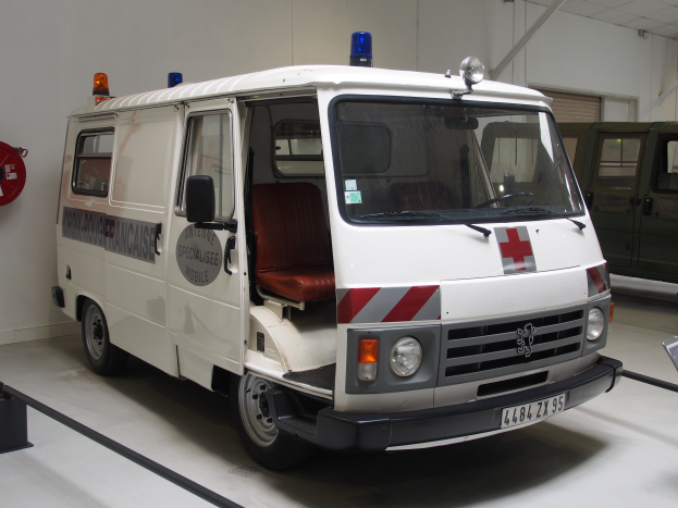 Ein Rettungswagen ist in einem Gebäude geparkt, in dem ein Feuerlöscher an der Wand zur linken Seite montiert ist.