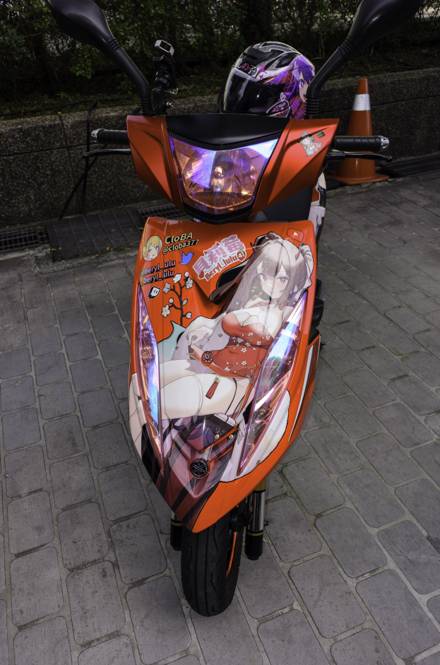 Ein oranges E-Scooter auf dem Straßenrand geparkt mit einem Helm darauf, mit einem Verkehrskegel, einer Wand und Bäumen im Hintergrund.