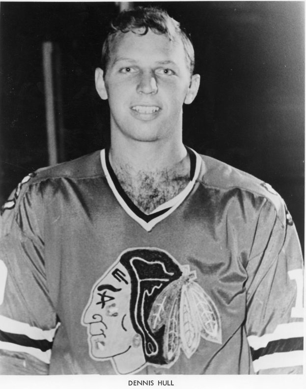 Ein Schwarz-Weiß-Foto eines grinsenden Hockey-Spielers in einem Trikot mit Text unten.